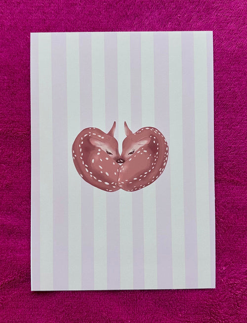 Note card with a fawn illustration on a striped background, placed on a purple surface