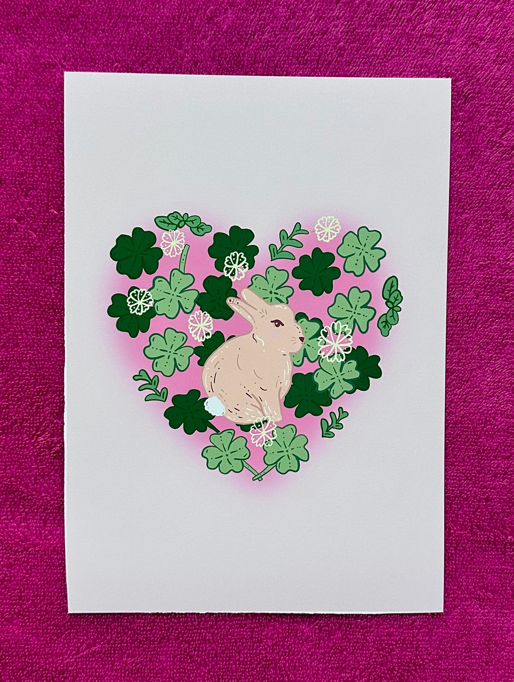 Card with a rabbit and clover heart design on a purple textured background