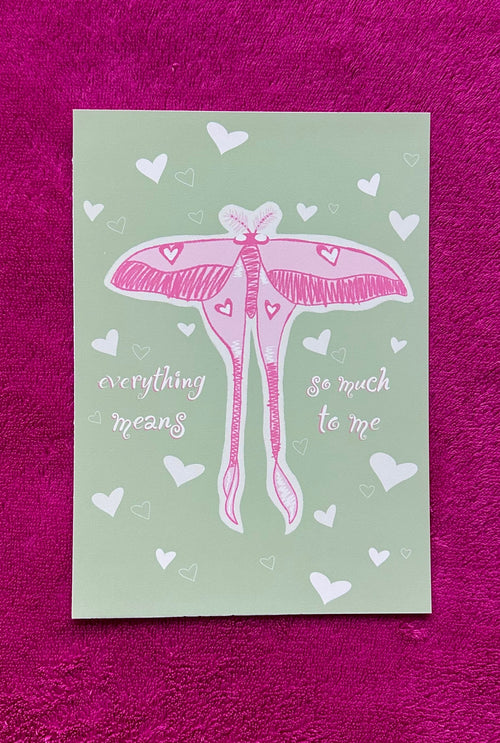 Card with pink butterfly illustration and text on a green background, placed on a purple textured surface.